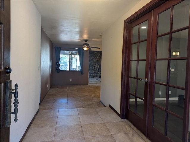 hall featuring light tile patterned floors and french doors