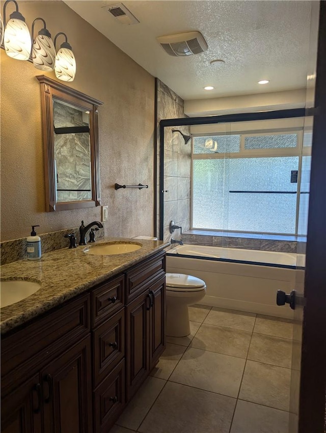 bathroom with tile patterned floors, a textured ceiling, toilet, and vanity