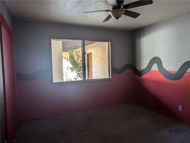 empty room featuring ceiling fan and carpet