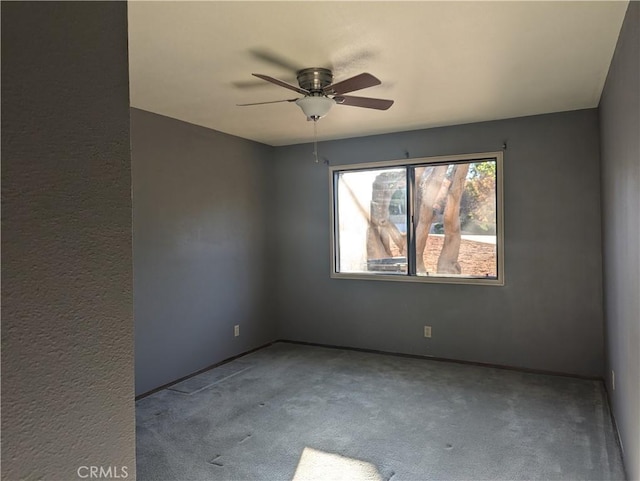 spare room with ceiling fan and light carpet