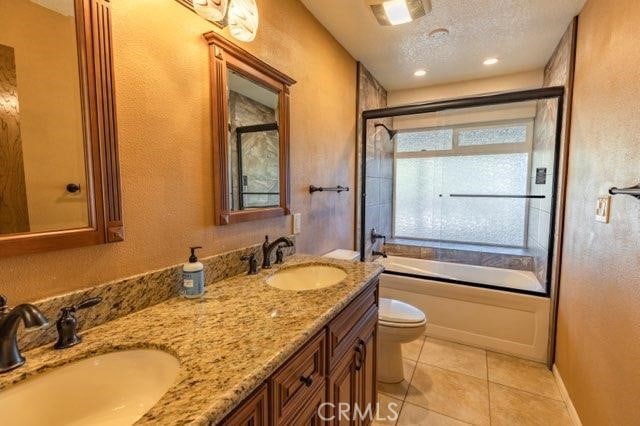 full bathroom featuring tile patterned floors, a textured ceiling, toilet, and independent shower and bath