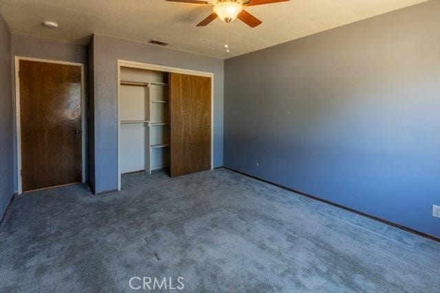 unfurnished bedroom featuring a closet, carpet, and ceiling fan