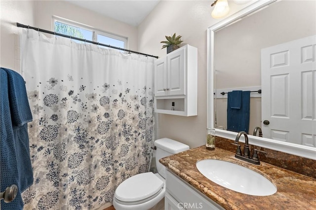 bathroom with curtained shower, vanity, and toilet