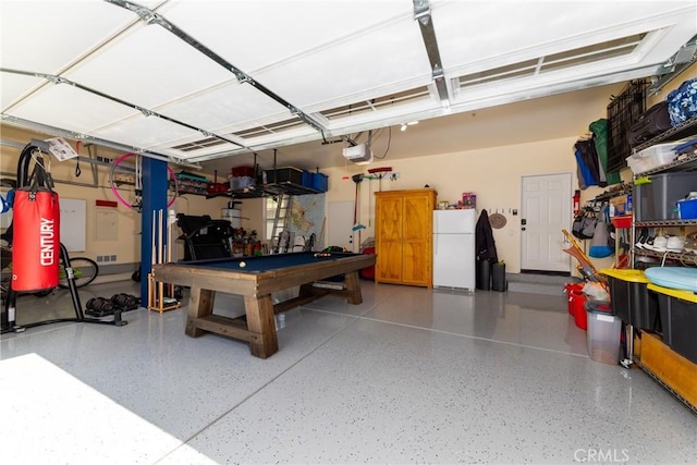 garage with white fridge and a garage door opener