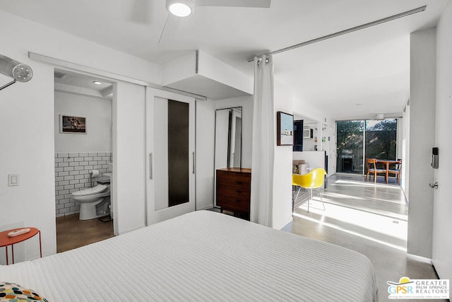 bedroom with ensuite bath, tile walls, and ceiling fan