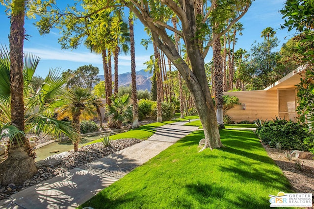 surrounding community with a mountain view and a lawn