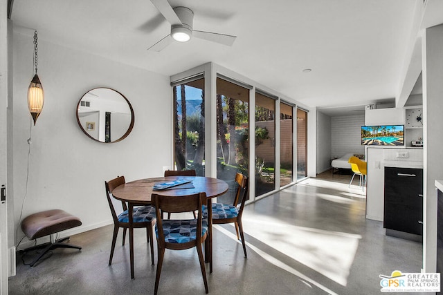 dining area featuring ceiling fan and expansive windows