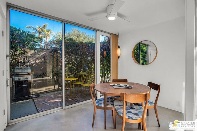 dining space with ceiling fan and a wall of windows