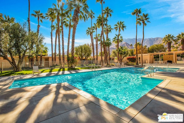 view of pool featuring a mountain view and a patio area