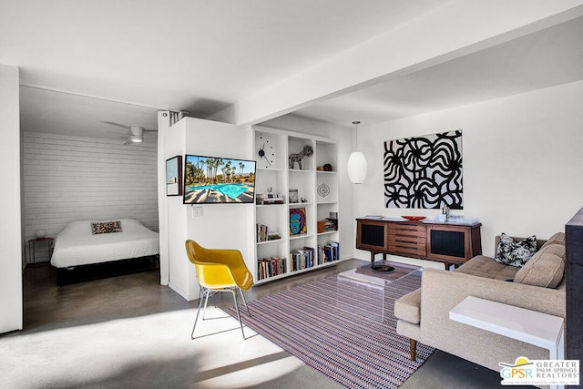 living room featuring ceiling fan, built in shelves, and concrete flooring