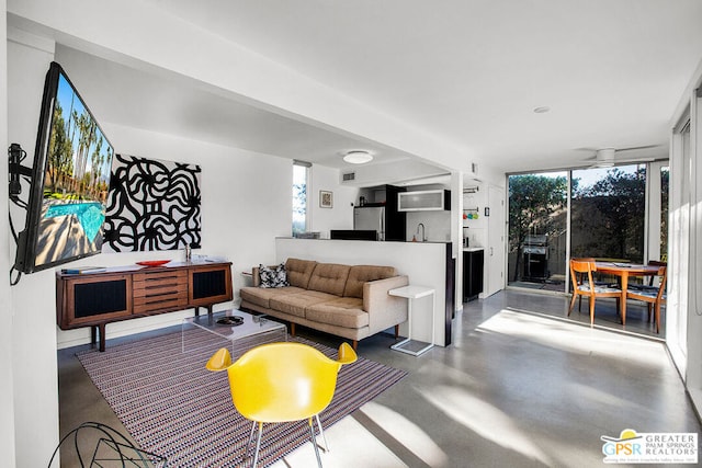 living room featuring expansive windows, a healthy amount of sunlight, and concrete floors