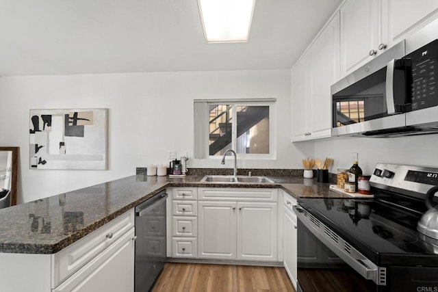 kitchen with white cabinets, stainless steel appliances, kitchen peninsula, and sink