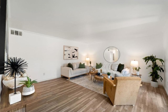 living room with hardwood / wood-style flooring and crown molding