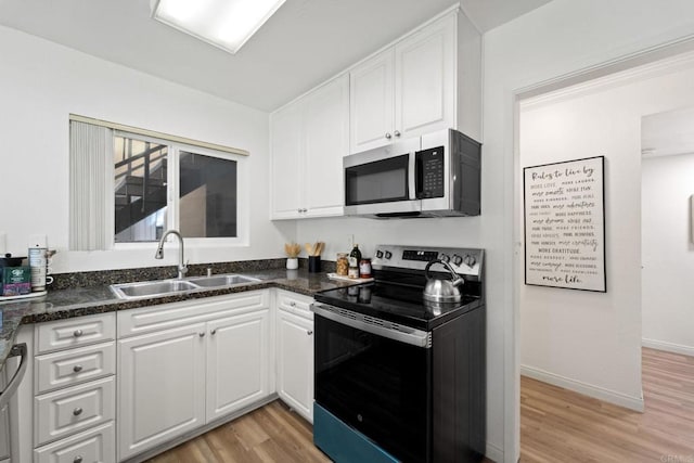 kitchen with stainless steel appliances, white cabinetry, light hardwood / wood-style floors, and sink