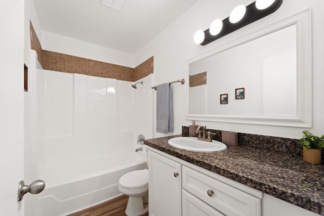 full bathroom featuring hardwood / wood-style floors, vanity, toilet, and bathtub / shower combination