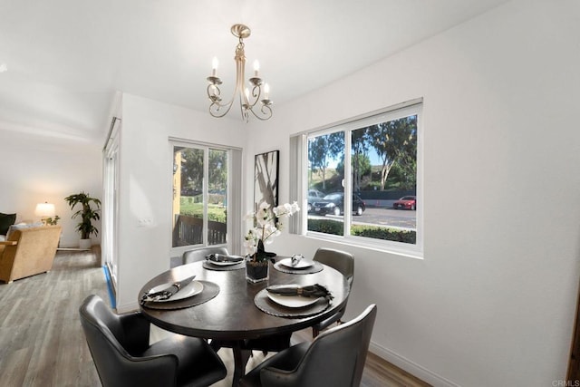 dining room featuring wood-type flooring and an inviting chandelier