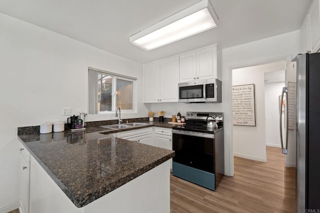 kitchen featuring white cabinetry, sink, kitchen peninsula, and stainless steel appliances