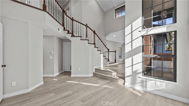 foyer featuring hardwood / wood-style flooring, a wealth of natural light, and a high ceiling