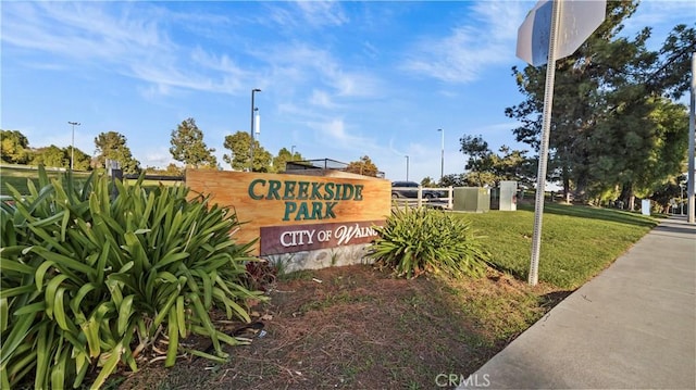 community / neighborhood sign featuring a yard