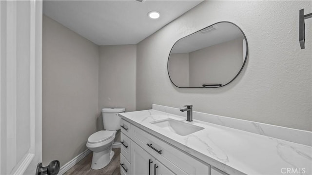 bathroom featuring vanity, hardwood / wood-style flooring, and toilet