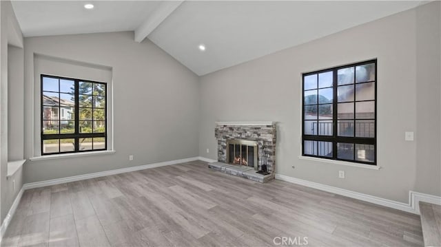 unfurnished living room featuring vaulted ceiling with beams, light wood-type flooring, and a stone fireplace