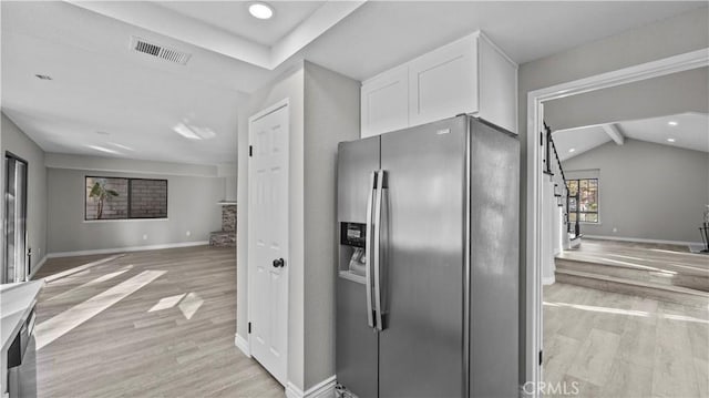 kitchen with white cabinets, stainless steel fridge with ice dispenser, lofted ceiling with beams, and light hardwood / wood-style floors