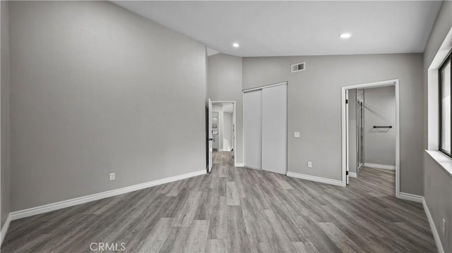 interior space with a closet, light hardwood / wood-style flooring, and lofted ceiling