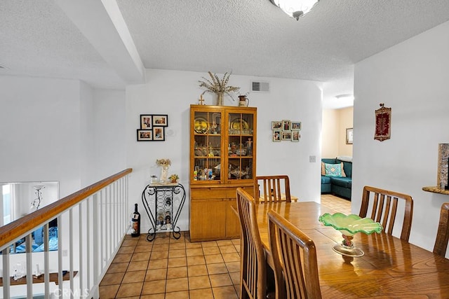 tiled dining area with a textured ceiling