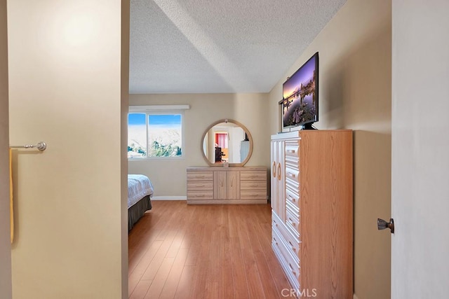 bedroom featuring light hardwood / wood-style floors and a textured ceiling