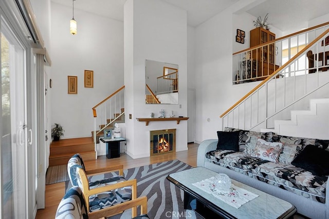 living room with a towering ceiling and wood-type flooring