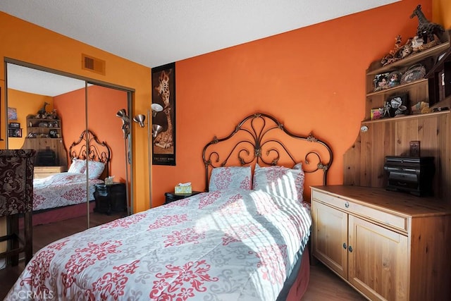 bedroom featuring a textured ceiling, a closet, and dark wood-type flooring