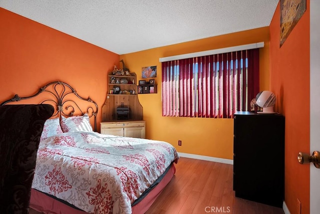 bedroom featuring hardwood / wood-style flooring and a textured ceiling