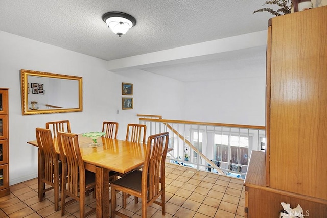 tiled dining room featuring a textured ceiling