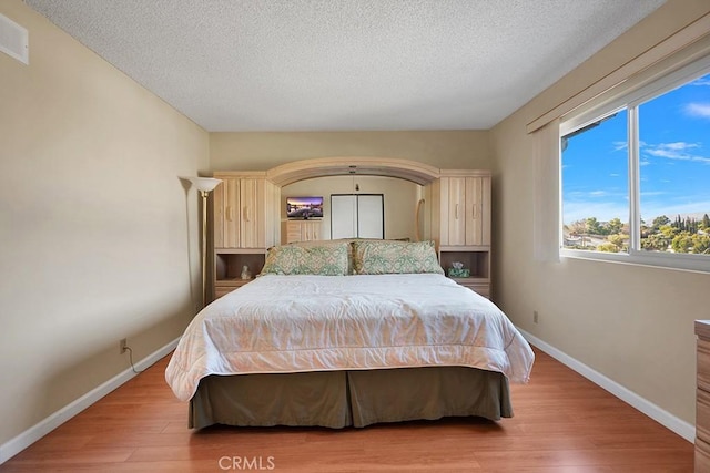 bedroom featuring wood-type flooring and a textured ceiling