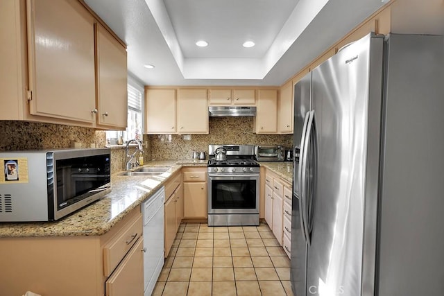 kitchen featuring light stone countertops, sink, stainless steel appliances, light brown cabinetry, and light tile patterned floors