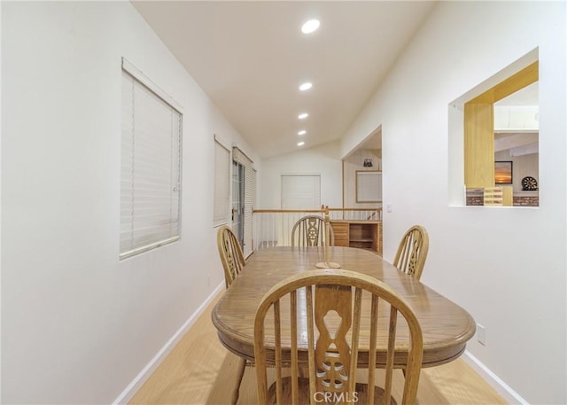 dining space featuring hardwood / wood-style floors and lofted ceiling