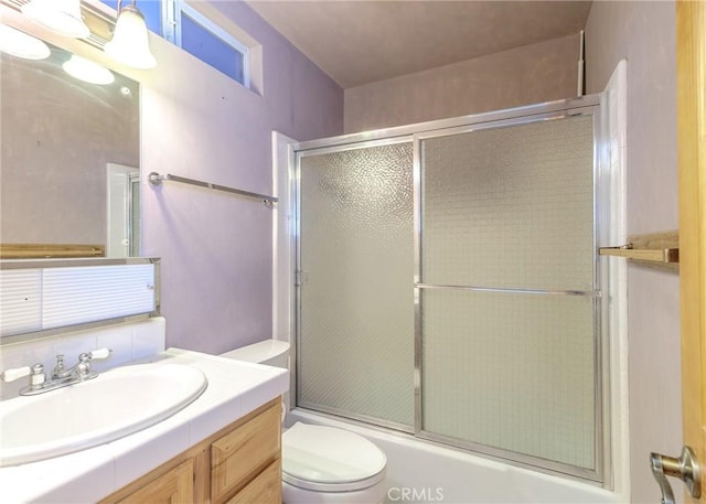 full bathroom featuring toilet, vanity, and combined bath / shower with glass door