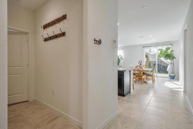 hall featuring light tile patterned flooring