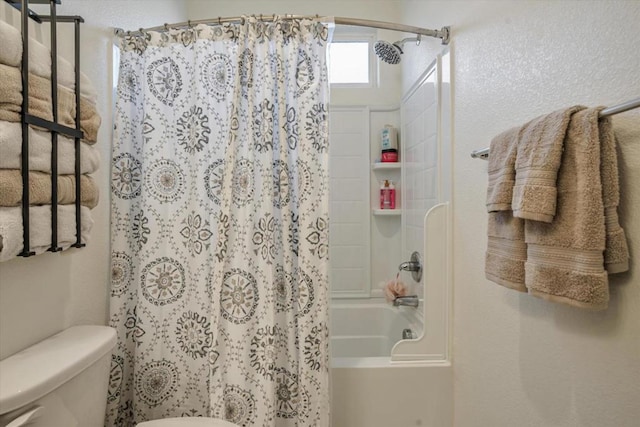 bathroom featuring shower / bathtub combination with curtain and toilet