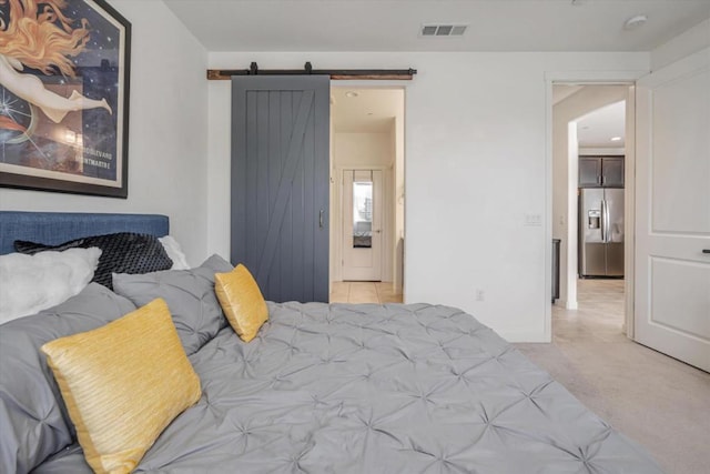 carpeted bedroom with stainless steel fridge and a barn door