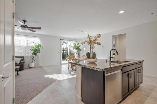 kitchen featuring sink, ceiling fan, a center island with sink, light carpet, and stainless steel dishwasher