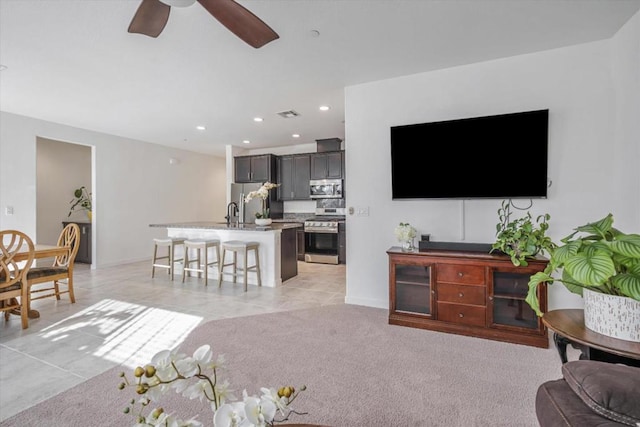 carpeted living room with sink and ceiling fan