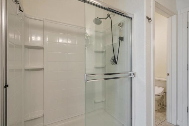 bathroom featuring walk in shower, toilet, and tile patterned flooring