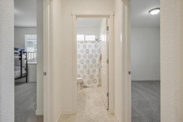 hallway with light colored carpet