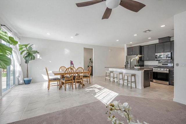 tiled dining space with ceiling fan