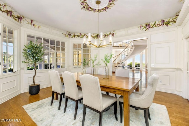 dining space featuring a chandelier, a wealth of natural light, and light hardwood / wood-style flooring