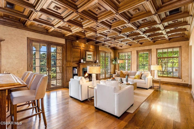 living room with beamed ceiling, french doors, light wood-type flooring, and coffered ceiling