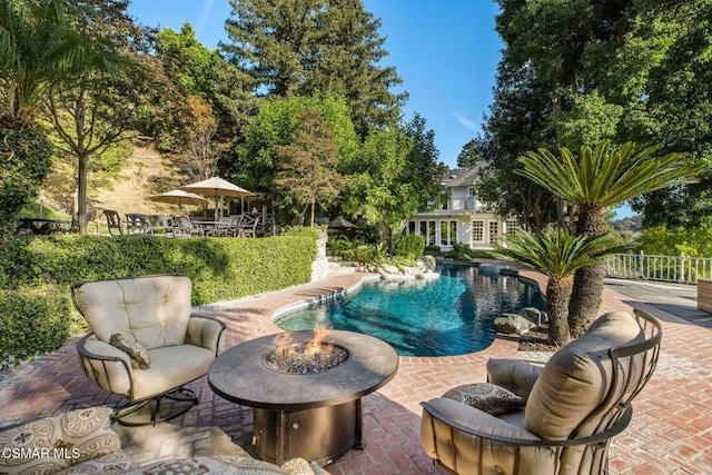 view of pool with a patio area and a fire pit