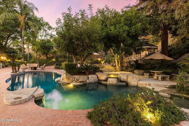 pool at dusk with a patio