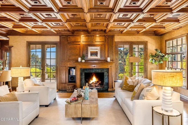 living room with french doors, a premium fireplace, coffered ceiling, and beam ceiling